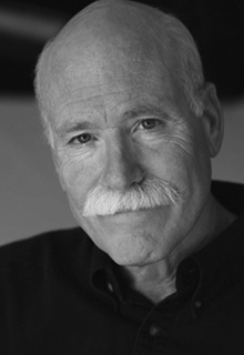 A black and white image of a white man wearing a black shirt